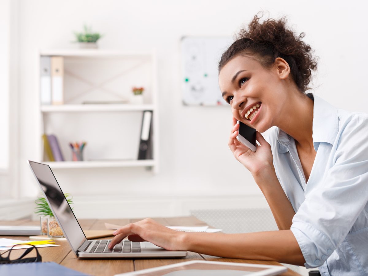 Assistante administrative au téléphone devant son ordinateur